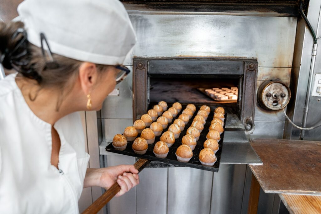 Baker checking the pastries in the oven